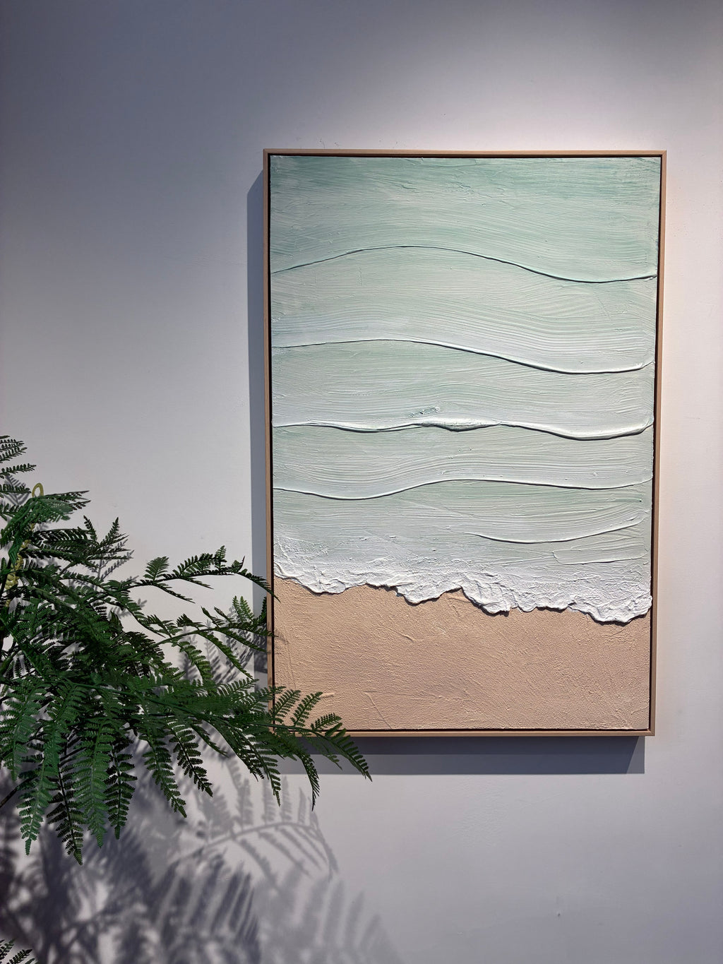 Close detail of the raised white foam line and sand texture