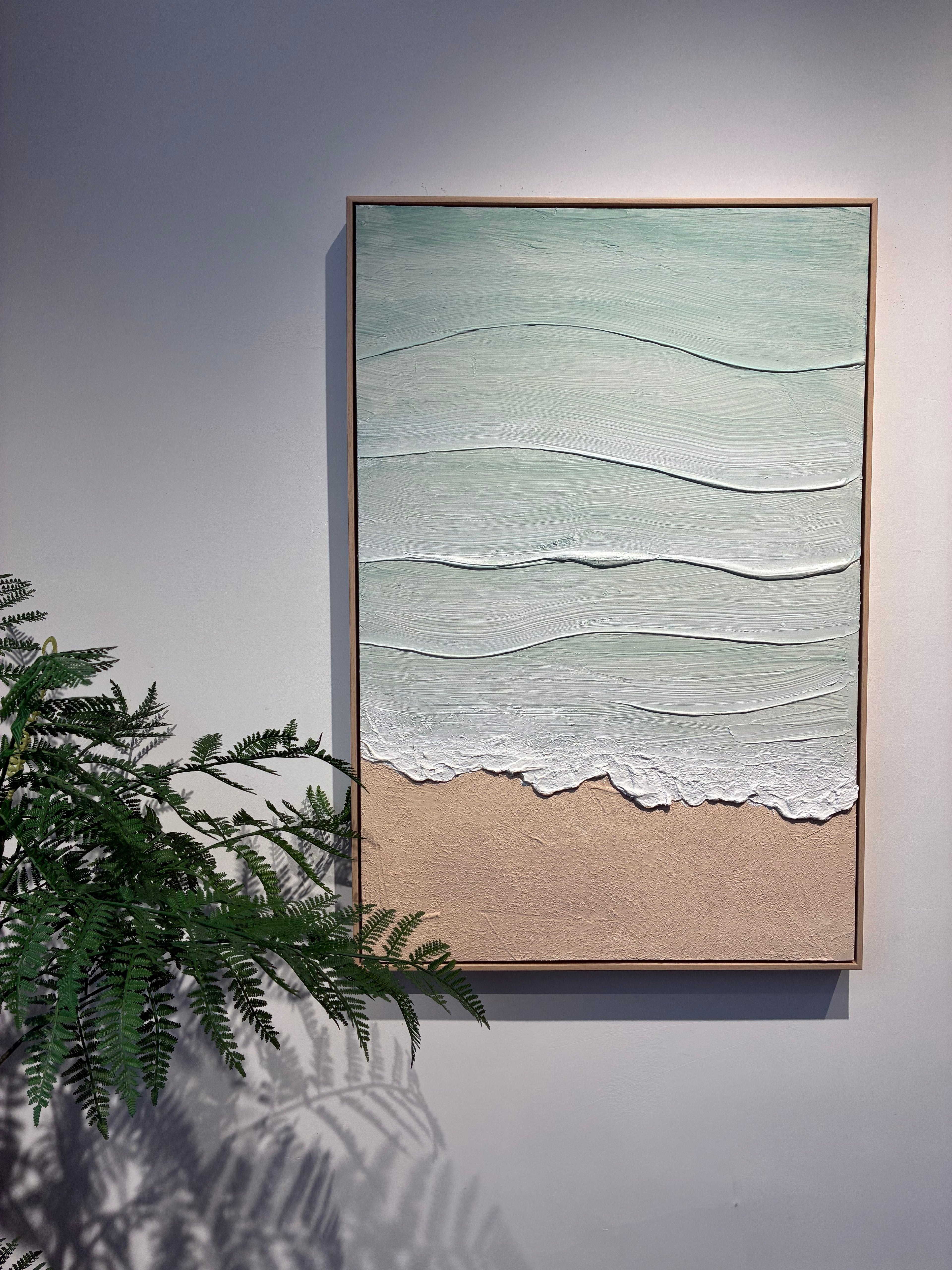 Close detail of the raised white foam line and sand texture