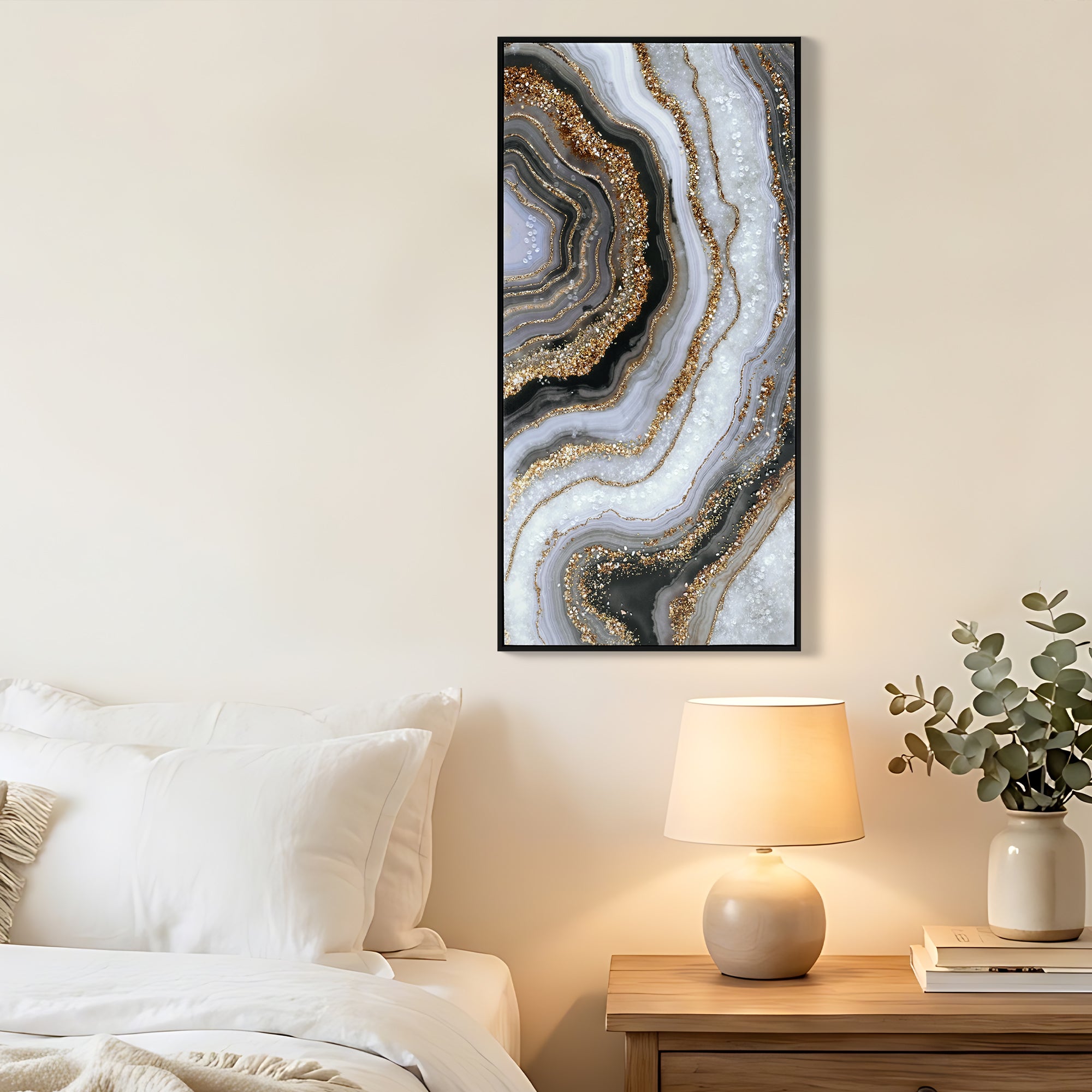 Geode canvas in a black frame hung beside a bed with a warm lamp